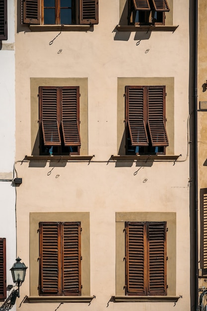 Nahaufnahme eines erstaunlichen alten traditionellen italienischen Steinhauses mit Gitterfensterläden in Florenz auf einem