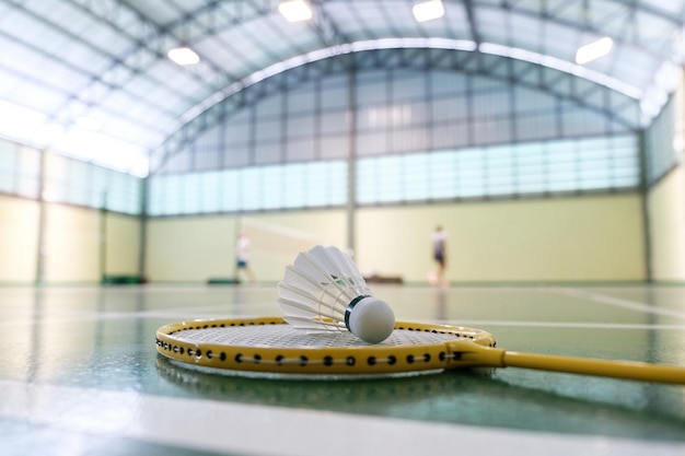 Foto nahaufnahme eines federballs auf einem badmintonschläger auf plätzen mit konkurrierenden spielern