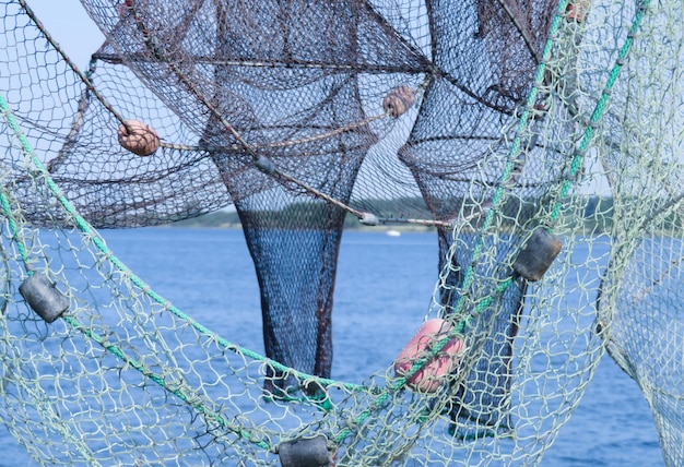 Nahaufnahme eines Fischernetzes, das am Meer hängt