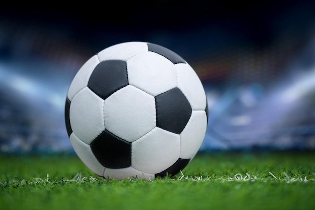 Nahaufnahme eines Fußballballs im grünen Gras auf einem Stadion