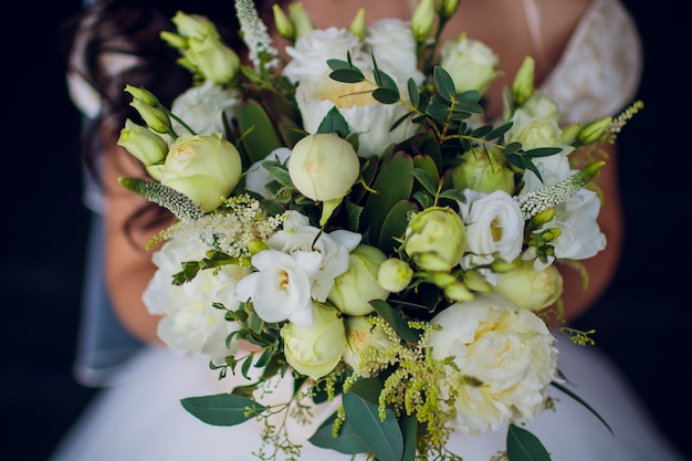 Nahaufnahme eines gedämpften Hochzeitsblumenstraußes mit rosa und lila Blumen.