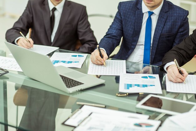 Nahaufnahme eines Geschäftsteams, das die Analyse von Marketingberichten am Arbeitsplatz im Büro durchführt.