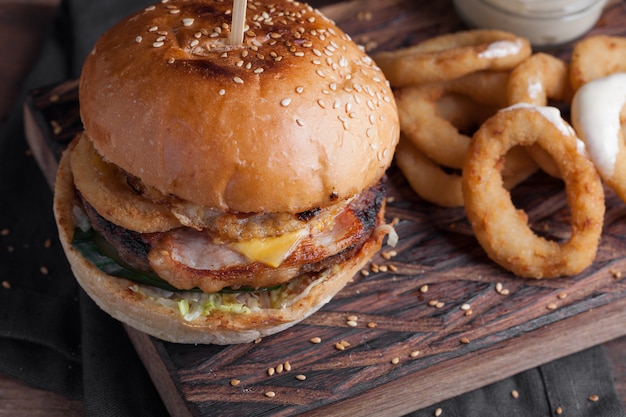 Nahaufnahme eines geschmackvollen Burgers mit Imbissen.