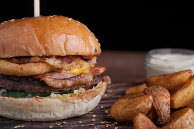 Nahaufnahme eines geschmackvollen Burgers mit Imbissen.