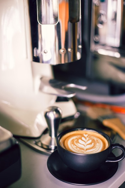 Nahaufnahme eines Getränks durch eine Kaffeemaschine auf dem Tisch