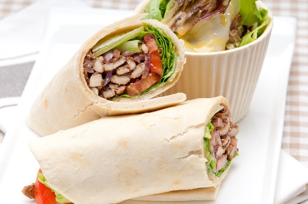 Nahaufnahme eines gewickelten Sandwichs in einem Teller auf dem Tisch