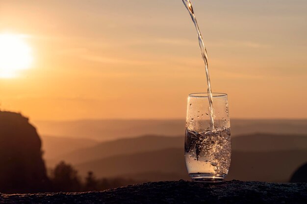 Foto nahaufnahme eines glases wasser gegen den himmel bei sonnenuntergang