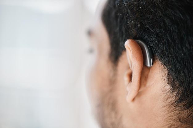 Nahaufnahme eines Hörgeräts oder des Ohrs eines Menschen mit Behinderung von hinten auf einem Modellplatz. Medizinisches Gerät für Gehörlose oder Implantat von Schallwellen, Audiologie oder Hilfe von Zubehör oder Unterstützung für Hörgeräte