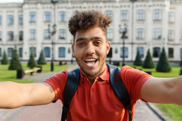 Nahaufnahme eines hübschen jungen männlichen Studenten, der im Freien ein Selfie macht