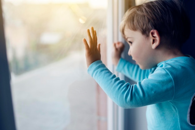 Foto nahaufnahme eines jungen, der durch ein glasfenster schaut