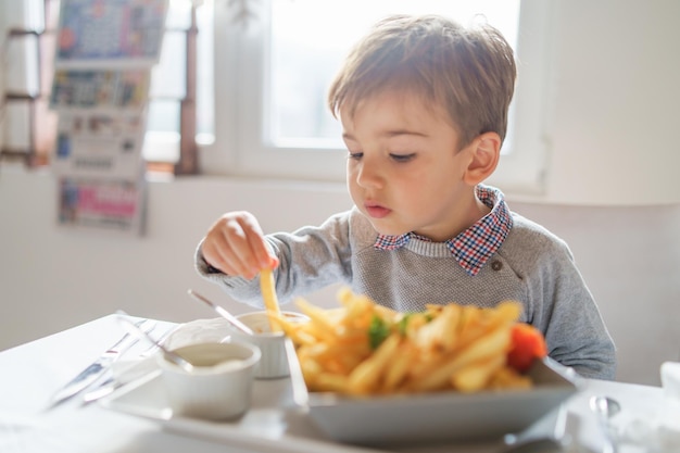 Nahaufnahme eines Jungen, der Pommes frites isst