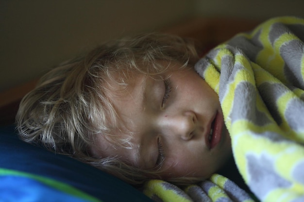 Foto nahaufnahme eines jungen, der zu hause im bett schläft