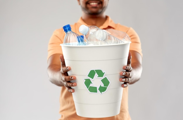 Nahaufnahme eines jungen indischen Mannes, der Plastikmüll sortiert