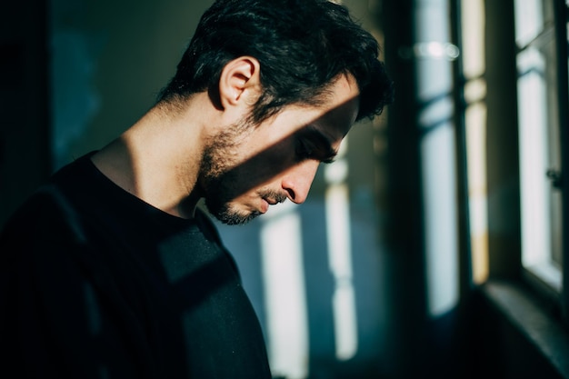 Nahaufnahme eines jungen Mannes am Fenster