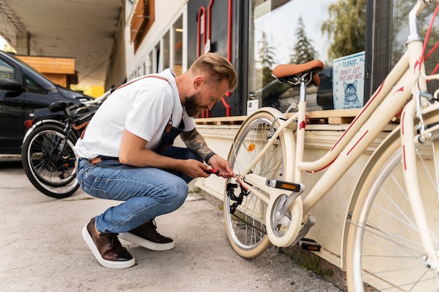 Nahaufnahme eines jungen Mannes, der an einem Fahrrad arbeitet