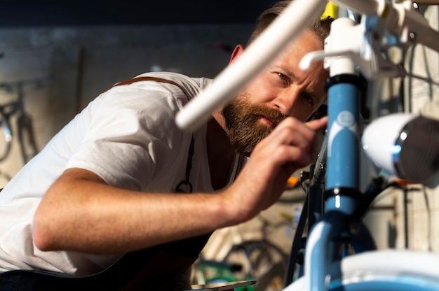 Foto nahaufnahme eines jungen mannes, der an einem fahrrad arbeitet
