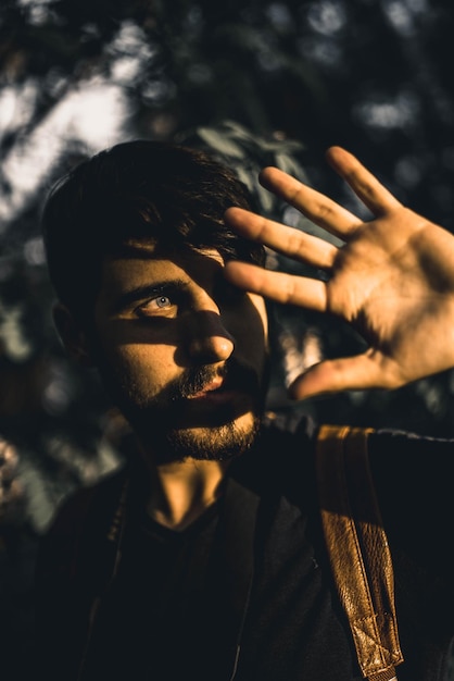 Nahaufnahme eines jungen Mannes, der im Wald wegblickt