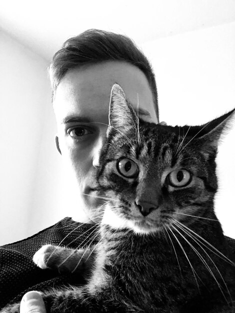 Foto nahaufnahme eines jungen mannes mit einer katze zu hause
