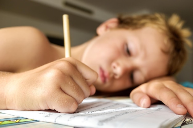 Foto nahaufnahme eines jungen mit einem buch auf dem tisch