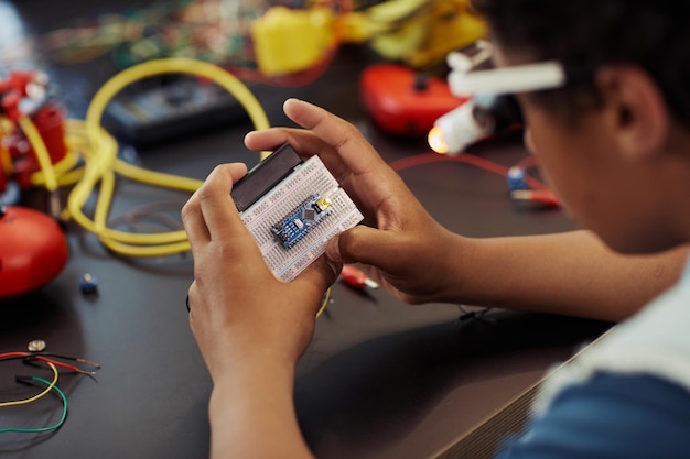 Nahaufnahme eines kleinen schwarzen Jungen, der im Ingenieurunterricht in der Schule Roboter baut