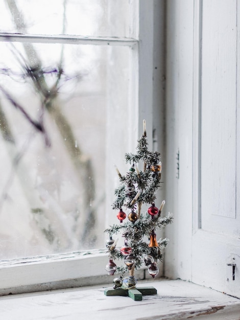Nahaufnahme eines kleinen Weihnachtsbaums auf dem Fensterbrett zu Hause