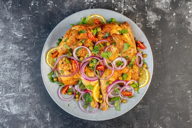 Nahaufnahme eines köstlichen Abendessens mit gebratenem Hühnchen mit verschiedenen Gewürzen und Lebensmitteln auf dunklem Hintergrund