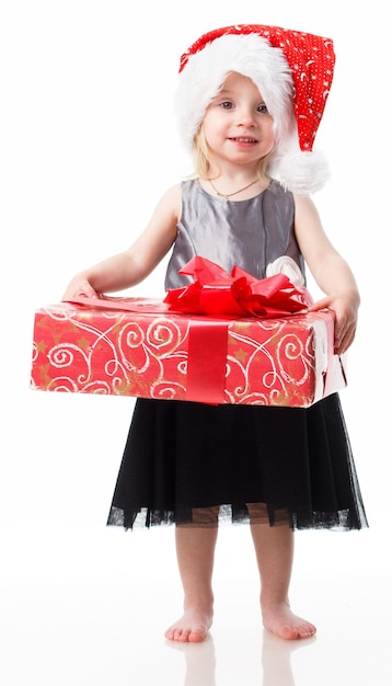 Nahaufnahme eines lächelnden kleinen Mädchens um das große Geschenk lokalisiert auf weißem Hintergrund