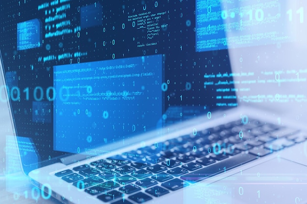 Nahaufnahme eines Laptops auf dem Desktop mit abstraktem, leuchtend blauem Codierungshintergrund Binärcode-Technologie-Daten und Internet-Konzept Doppelbelichtung