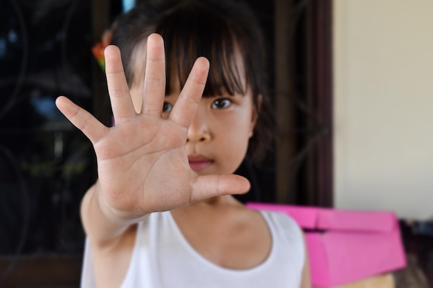 Nahaufnahme eines Mädchens, das die Hand zeigt, um gegen Gewalt und Schmerz aufzuhören