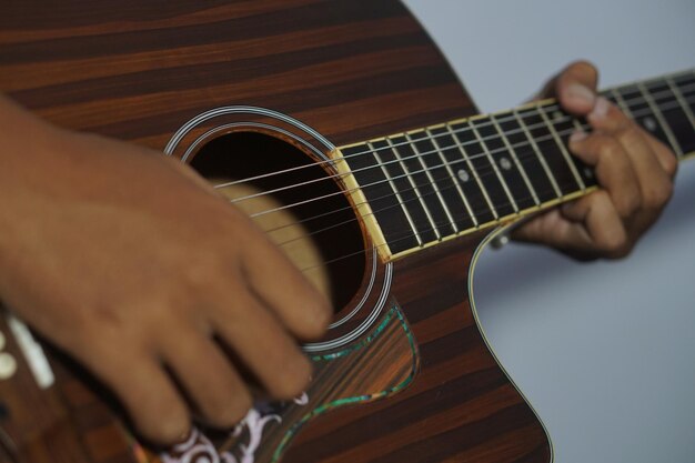 Foto nahaufnahme eines mannes, der akustische gitarre spielt