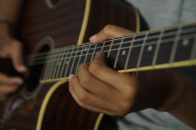 Foto nahaufnahme eines mannes, der akustische gitarre spielt