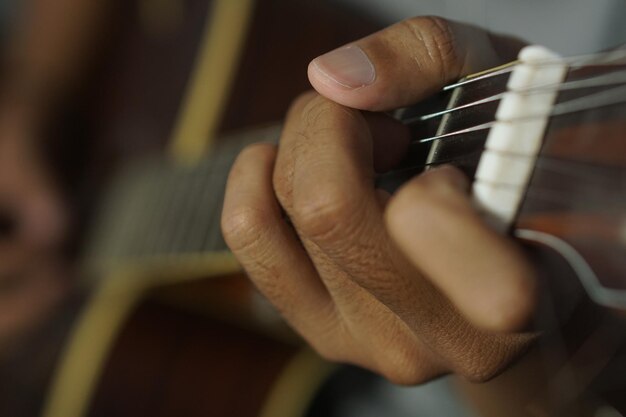 Foto nahaufnahme eines mannes, der akustische gitarre spielt