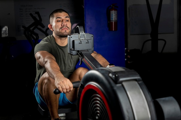 Nahaufnahme eines Mannes, der auf einer Maschine in einem Crossfit-Fitnessstudio rudert