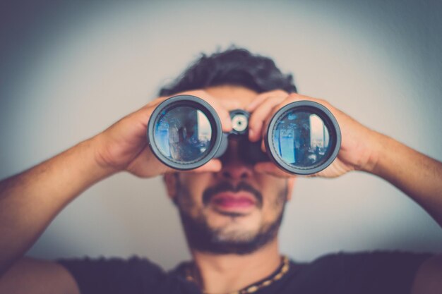 Foto nahaufnahme eines mannes, der durch ein fernglas schaut