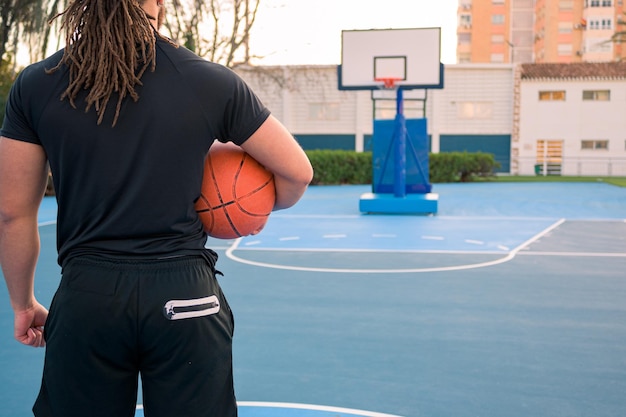 Nahaufnahme eines Mannes, der einen Ball auf einem Basketballplatz hält