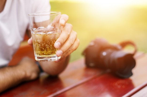 Foto nahaufnahme eines mannes hält ein glas bier.