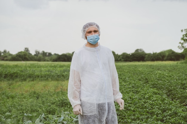 Nahaufnahme eines Mannes in einem Schutzanzug und einer medizinischen Maske im Freien