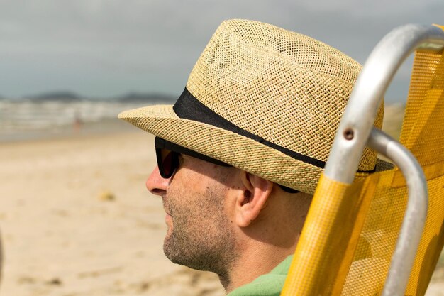 Nahaufnahme eines Mannes mit Hut am Strand