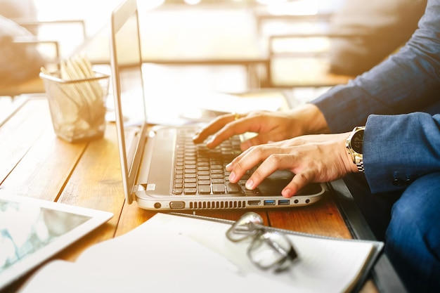 Nahaufnahme eines Mannes mit Laptop auf dem Tisch