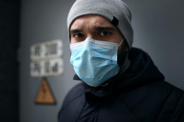 Nahaufnahme eines Mannes mit medizinischer Maske im Freien, der an einer Virusepidemie erkrankt ist