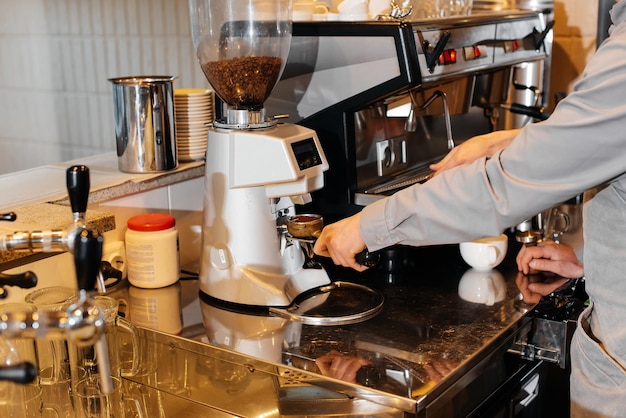Nahaufnahme eines maskierten Bartista, der köstlichen, köstlichen Kaffee an der Bar in einem Café zubereitet Die Arbeit von Restaurants und Cafés während der Pandemie