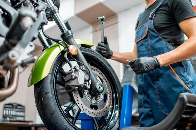 Nahaufnahme eines Mechanikers, der ein Motorrad repariert