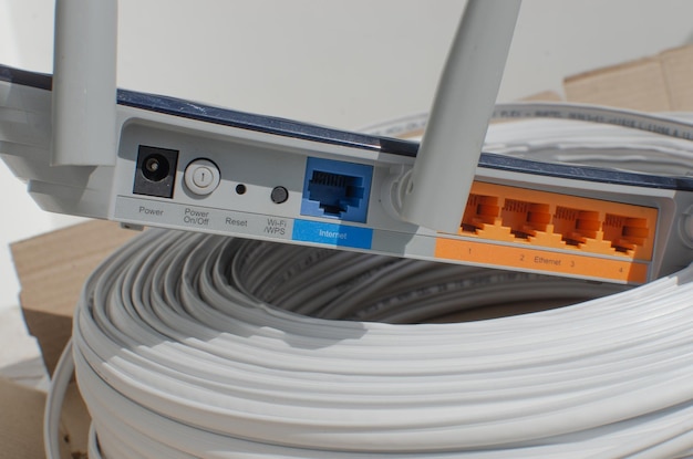 Nahaufnahme eines modernen WLAN-Routers mit mehreren Eingängen und Anschlüssen für Kabelverbindungen, die Internettechnologie und -verbindungen darstellen