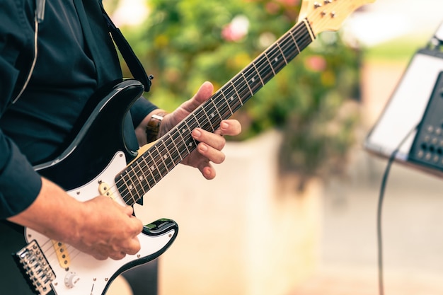 Nahaufnahme eines Musikers, der bei einem Live-Konzert im Freien eine E-Gitarre spielt