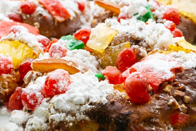 Nahaufnahme eines Obst-Weihnachtskuchens mit bunten Gelees und Zuckerpulver
