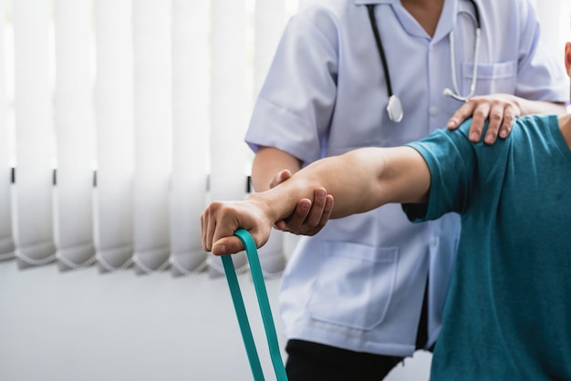 Nahaufnahme eines Physiotherapeuten, der einen Patienten in einer Klinik behandelt.