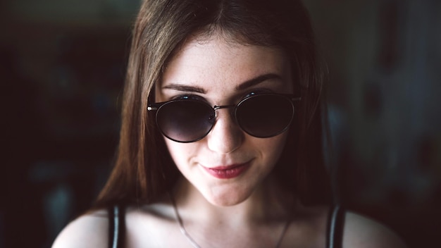 Nahaufnahme eines Porträts einer jungen Frau mit Sonnenbrille