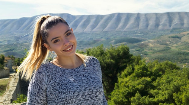 Nahaufnahme eines Porträts einer schönen Frau, die gegen die Landschaft steht
