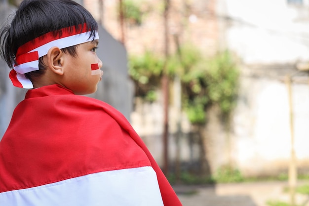 Foto nahaufnahme eines porträts indonesischer kinder mit indonesischer flagge