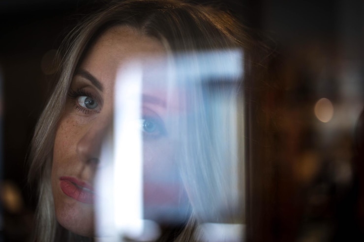Foto nahaufnahme eines portraits einer frau an einem glasfenster